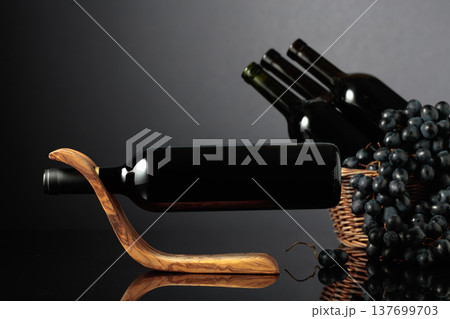 Red wine and blue grapes on a black reflective background. Red wine and blue grapes on a black reflective background. 137699703
