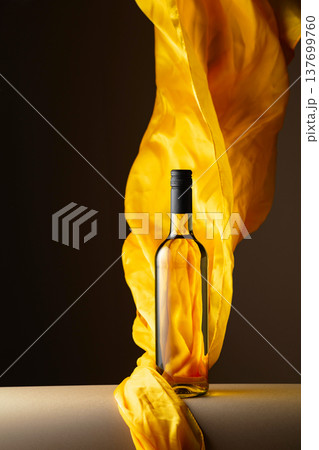 Bottle of white wine and flutters of yellow cloth. Bottle of white wine and flutters of yellow cloth. 137699760
