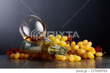 Grapes and white wine on a black background. 137699769