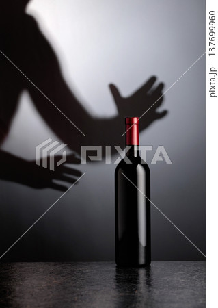 Bottle of red wine on a black table. 137699960