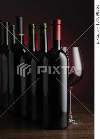 Bottles of red wine on a old wooden table. Bottles of red wine on a old wooden table. 137699961