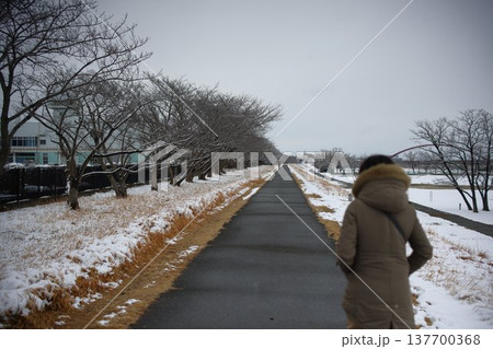 雪の中を歩く女性 137700368