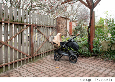 black and beige baby stroller parked close to gate black and beige baby stroller parked close to gate 137700614