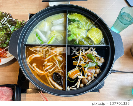 4種類のスープが入った特別な鍋で食べる料理。それぞれに野菜が煮込まれている。 4種類のスープが入った特別な鍋で食べる料理。それぞれに野菜が煮込まれている。 137701323