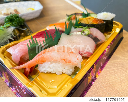 プラスチック容器に入った握り寿司。甘エビ、真鯛、マグロなど。 プラスチック容器に入った握り寿司。甘エビ、真鯛、マグロなど。 137701405