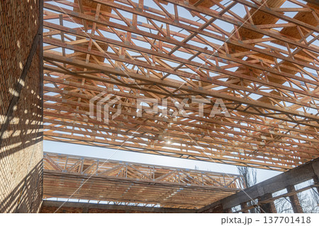 Wooden Roof Trusses Construction on Building Site with Blue Sky Background.roofing works Wooden Roof Trusses Construction on Building Site with Blue Sky Background.roofing works 137701418