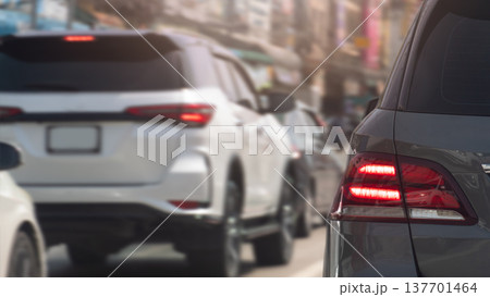Rear side view of grey car with turn on brake signal. Can see speed of car by blurred speed of other cars and city on the road. Rear side view of grey car with turn on brake signal. Can see speed of car by blurred speed of other cars and city on the road. 137701464