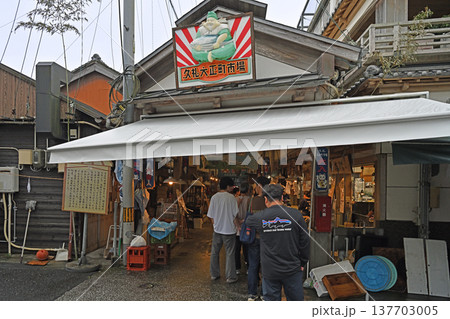 観光客で賑わう市場の入り口 恵比寿様とカツオの看板が迎える漁師町の商店街 137703005