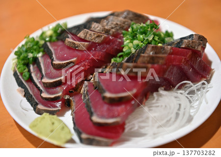 高知名物の鰹の藁焼きタタキ 薬味を添えた新鮮なカツオの刺身盛り付け 137703282