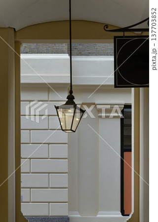 Architectural grace meets understated charm in this study of light and shadow. Defined by pale yellow archways and robust white columns, the passage offers a classical, inviting threshold. A textured Architectural grace meets understated charm in this study of light and shadow. Defined by pale yellow archways and robust white columns, the passage offers a classical, inviting threshold. A textured 137703852