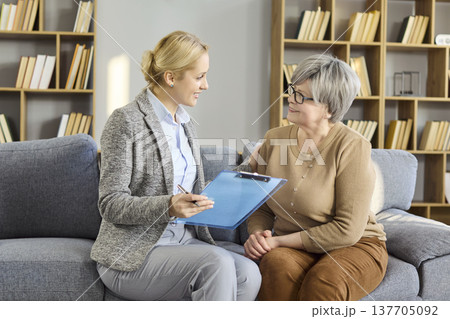 Senior client meeting with advisor at home financial consultation and paperwork 137705092