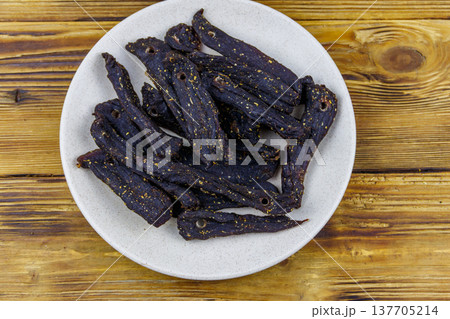 Slices of biltong (South African dried meat) on wooden table. Top view 137705214
