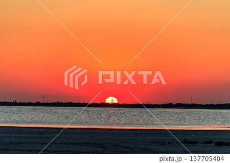 Beautiful orange sunset over a salt lake Beautiful orange sunset over a salt lake 137705404