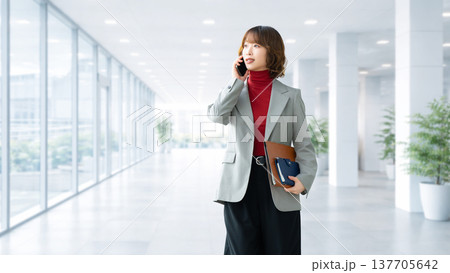 スマートフォンで話す女性・ビジネスウーマン 137705642