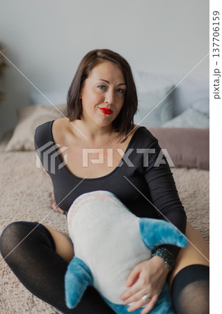 Beautiful woman posing for photographer on bed in 137706159