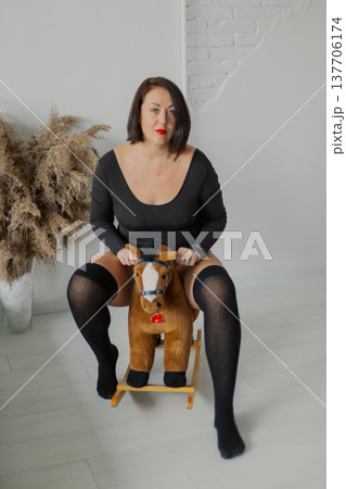 Beautiful woman posing for photographer near wall 137706174