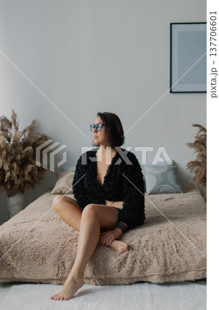 Beautiful woman posing for photographer on bed in Beautiful woman posing for photographer on bed in 137706601