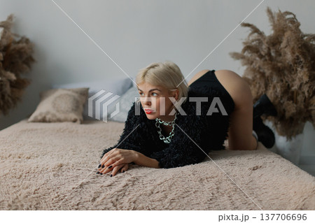 Beautiful woman posing for photographer on bed in Beautiful woman posing for photographer on bed in 137706696