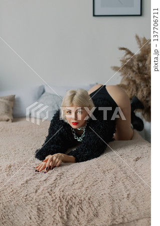 Beautiful woman posing for photographer on bed in Beautiful woman posing for photographer on bed in 137706711