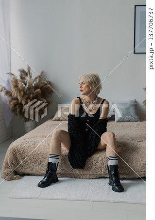 Beautiful woman posing for photographer on bed in 137706737