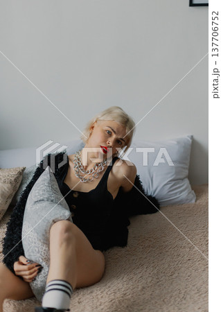 Beautiful woman posing for photographer on bed in 137706752