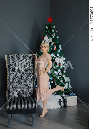 A woman stands at full height near a New Year tree 137706914