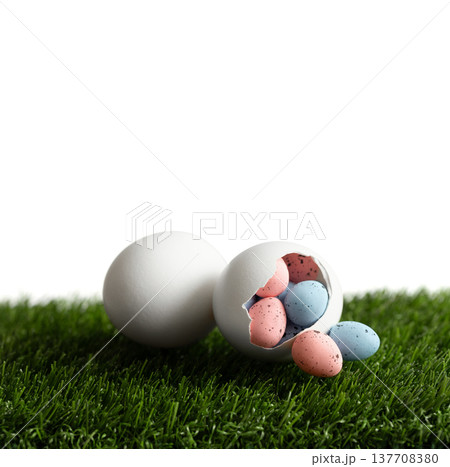 Easter composition with small painted eggs in a hatched white chicken egg on a green lawn. Festive Easter decor isolated on white background. Copy space. Easter composition with small painted eggs in a hatched white chicken egg on a green lawn. Festive Easter decor isolated on white background. Copy space. 137708380