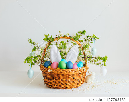 Easter composition with colorful painted eggs in a flower basket on white background. Happy Easter time. 137708382