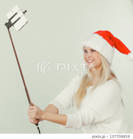 Woman in Santa hat taking Christmas selfie 137709859
