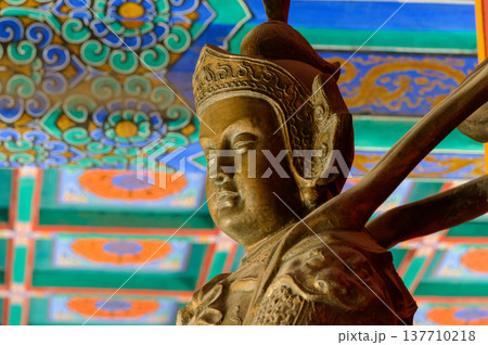 Asian Guardian Statue Under Colorful Temple Ceiling Asian Guardian Statue Under Colorful Temple Ceiling 137710218