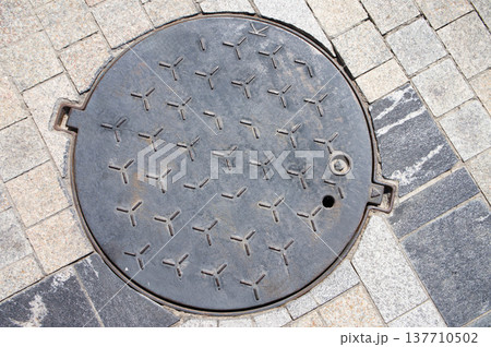 A grey manhole cover with the number 2012. A grey manhole cover with the number 2012. 137710502