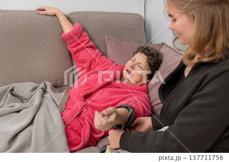 Caregiver measuring blood pressure of senior woman at home Caregiver measuring blood pressure of senior woman at home 137711756