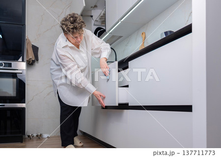 Senior woman cleaning kitchen countertop at home Senior woman cleaning kitchen countertop at home 137711773