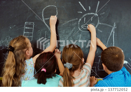 Children drawing together on a classroom chalkboard, collaborative creativity and playful teamwork Children drawing together on a classroom chalkboard, collaborative creativity and playful teamwork 137712052
