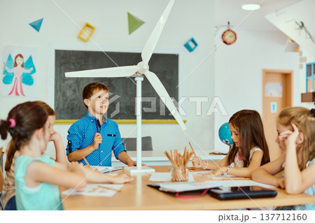 Children presenting a wind turbine model in a classroom science project about renewable energy and sustainability 137712160