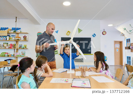 Teacher and students building a wind turbine model during a hands-on science lesson in classroom 137712166