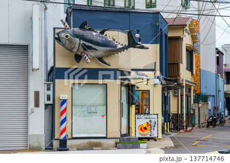 Osaka, Japan - Sep 23 2024, Panoramic view of the barbershop decorated with a sculpture of tuna pierced by a barberpole, at daytime, without people, Osaka, Japan 137714746