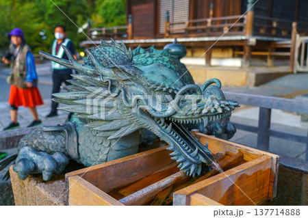 Kyoto, Japan - Sep 23 2024, Close-up view of the head of a bronze statue of a Chinese dragon, at entrance of Temple of Pure Water, Kiyomizu-dera Temple, with people in the background, Kyoto, Japan Kyoto, Japan - Sep 23 2024, Close-up view of the head of a bronze statue of a Chinese dragon, at entrance of Temple of Pure Water, Kiyomizu-dera Temple, with people in the background, Kyoto, Japan 137714888