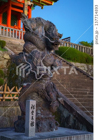 Kyoto, Japan - Sep 23 2024, vertical, close-up view of stone statue of two writhing dragons near stairs in front of entrance to Pure Water Kiyomizu Dera Temple, with shrine on background, Kyoto, Japan 137714893