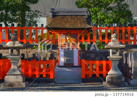 Kyoto, Japan - Sep 23 2024, Close-up view of a small Shinto shrine with a red wooden fence and two stone toro lanterns, at Fushimi Inari shrine, at daytime, without people, Kyoto, Japan Kyoto, Japan - Sep 23 2024, Close-up view of a small Shinto shrine with a red wooden fence and two stone toro lanterns, at Fushimi Inari shrine, at daytime, without people, Kyoto, Japan 137714918