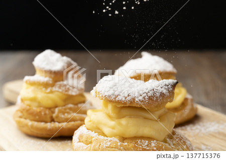 手作りシュークリームの仕上げに粉糖をふるう 137715376