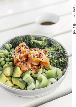 smoked salmon and green vegetable healthy poke bowl on white table in melbourne australia cafe smoked salmon and green vegetable healthy poke bowl on white table in melbourne australia cafe 137716062