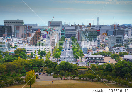 Himeji, Japan - Sep 24 2024, panoramic aerial view from window of White Heron Castle to park in front of castle and city of Himeji, with people on courtyard, at daytime with cloudy sky, Himeji, Japan 137716112