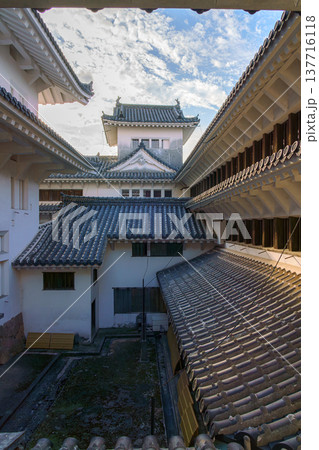 Himeji, Japan - Sep 24 2024, vertical, panoramic view from window of roofs and towers with roof tiles in courtyard of Himeji Castle, White Heron Castle, at daytime with cloudy sky, Himeji, Japan Himeji, Japan - Sep 24 2024, vertical, panoramic view from window of roofs and towers with roof tiles in courtyard of Himeji Castle, White Heron Castle, at daytime with cloudy sky, Himeji, Japan 137716118