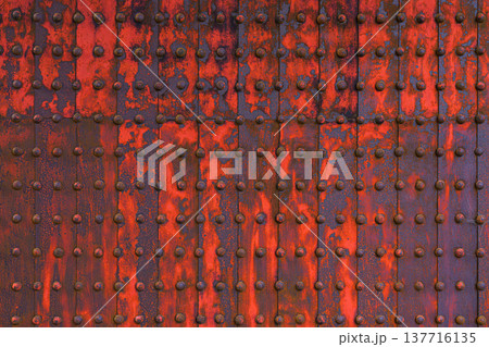 Himeji, Japan - Sep 24 2024, a close-up view of metal surface consisting of iron sheets with many rivets, partially covered with red paint and rust, aged, part of gate of Himeji Castle, Himeji, Japan 137716135