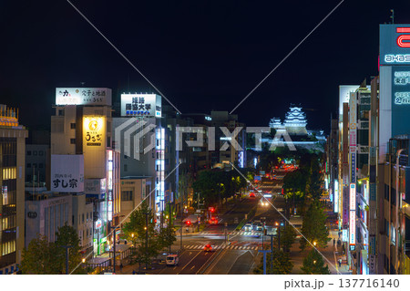 Himeji, Japan - Sep 24 2024, panoramic aerial view of Himeji central street with the White Heron Castle in the background, at night with the lights on, cars driving along the road, Himeji, Japan 137716140