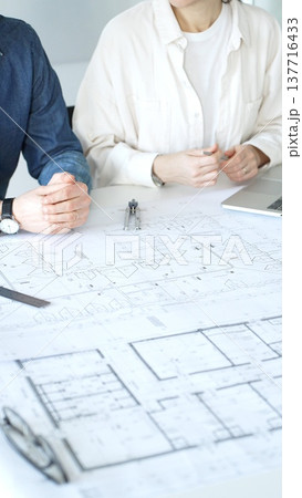 Architects collaborating on architectural project, discussing building design plans, creating new house models, developing urban construction schemes, working in modern office Architects collaborating on architectural project, discussing building design plans, creating new house models, developing urban construction schemes, working in modern office 137716433