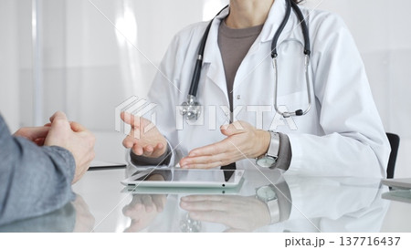 Female doctor consulting patient, explaining treatment options, discussing healthcare in clinic, providing medical advice. Medicine and health care 137716437