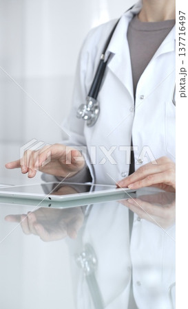 Doctor person using digital tablet, providing modern medical consultation and health insurance support information. Medicine and health care Doctor person using digital tablet, providing modern medical consultation and health insurance support information. Medicine and health care 137716497