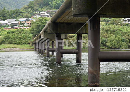 四万十川に架かる岩間沈下橋の堅牢な橋脚と続く道 137716892